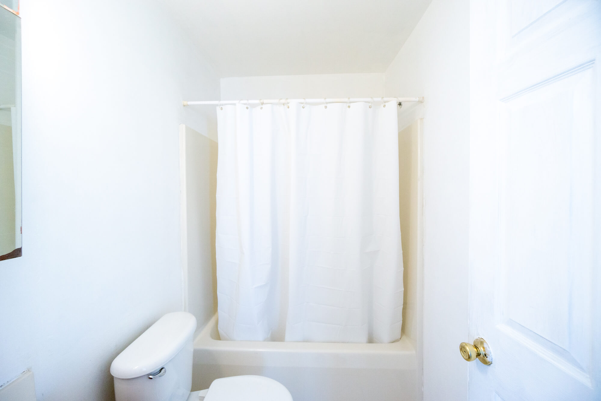 First floor bathroom facing the tub and toilet.