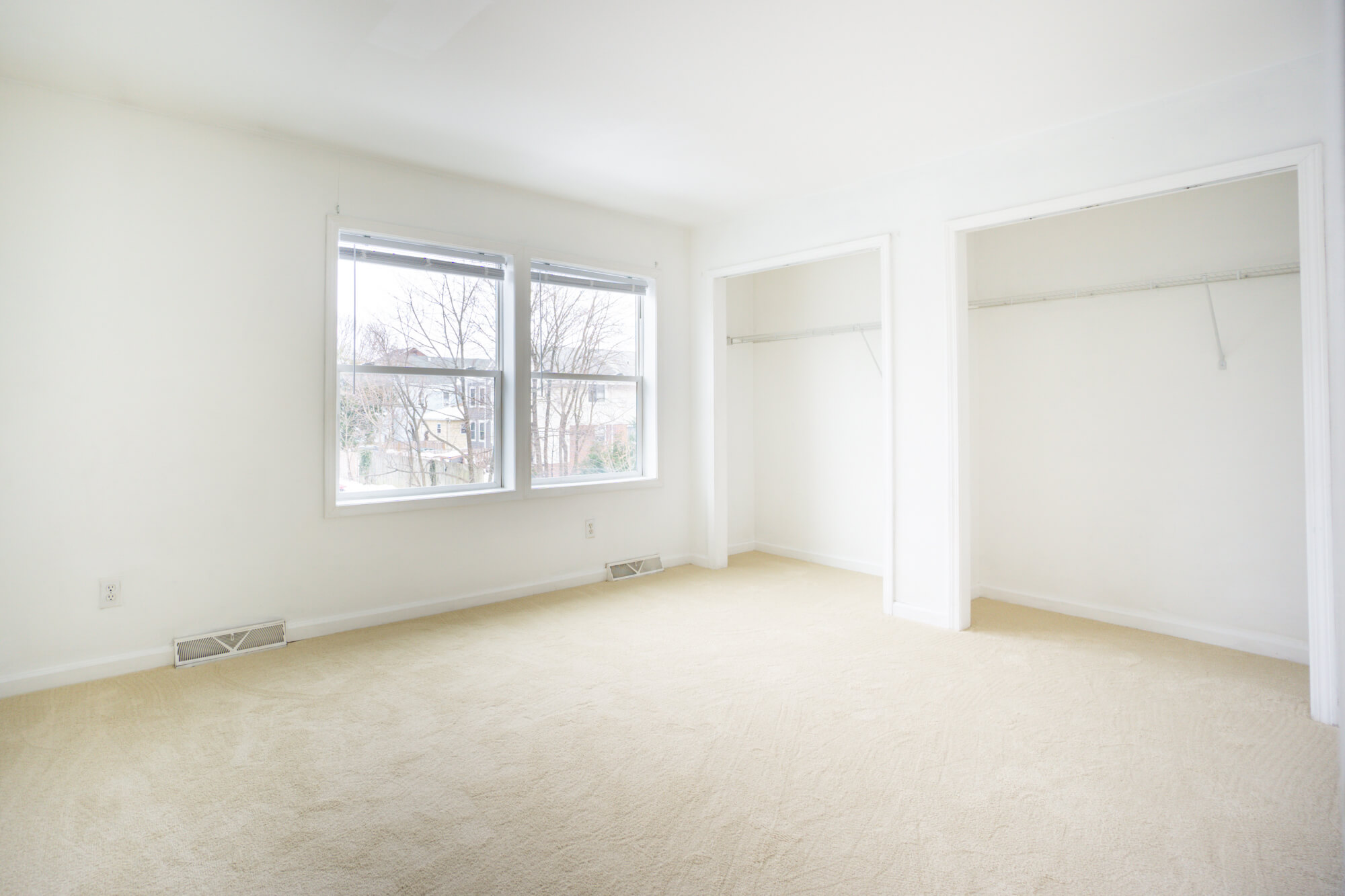 Second floor double bedroom with windows and closets.