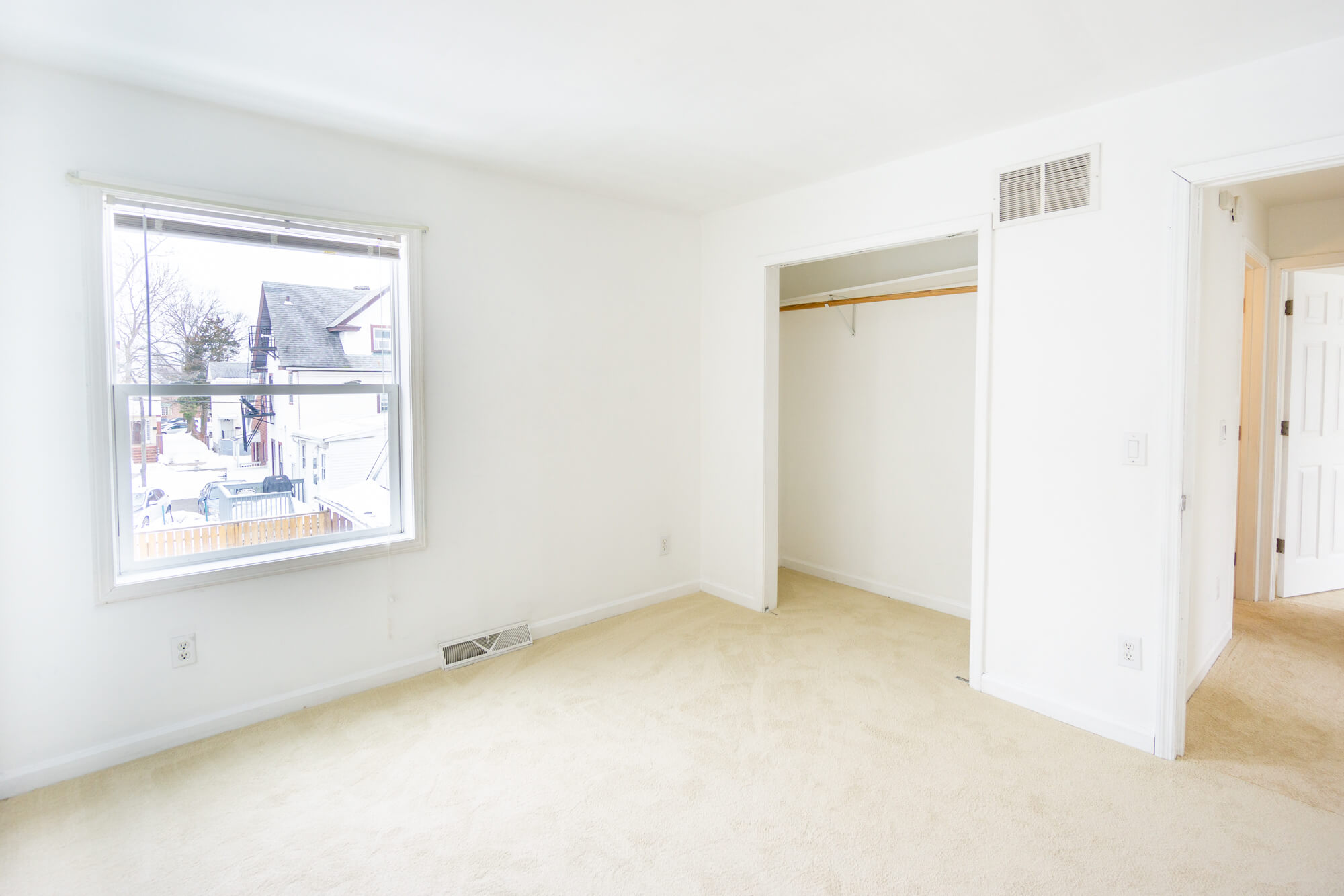 Second floor single bedroom with a window, closet, and opened door.